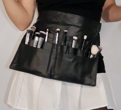 Professional makeup brushes in a leather belt